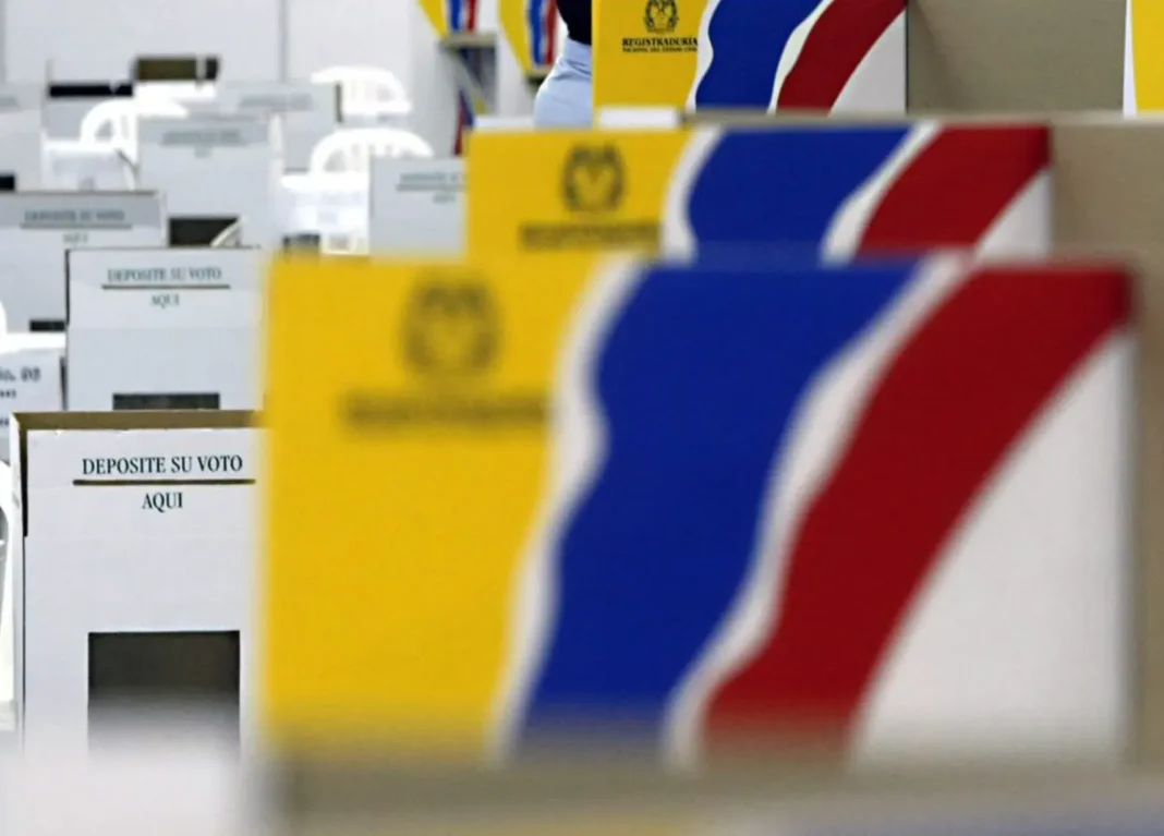 Urnas electorales y bandera de Colombia en fondo
